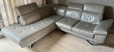 Divano in pelle ad angolo con segni di usura