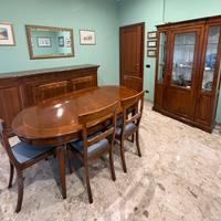 Sala completa di tavolo, sedie, vetrina e credenza