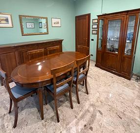 Sala completa di tavolo, sedie, vetrina e credenza