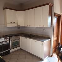 Cucina bianca con granito, forno e lavastoviglie.