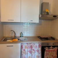 Cucina Bianca con tavolo, sedie e frigorifero