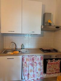 Cucina Bianca con tavolo, sedie e frigorifero