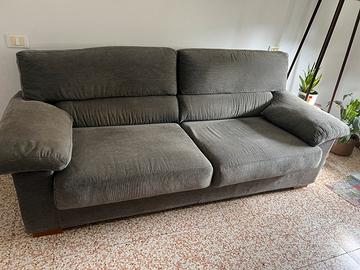 Comodo divano in velluto grigio a costine.