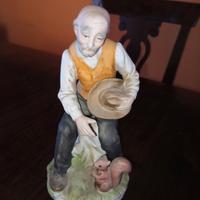 statuina porcellana, anziano con scoiattolo