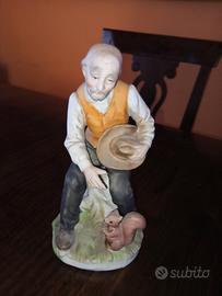 statuina porcellana, anziano con scoiattolo