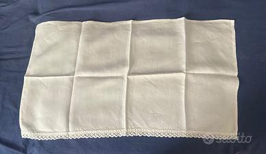 Tovaglietta bianca in lino con bordo in pizzo.