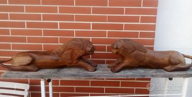 copia di leoni intagliati su legno teak