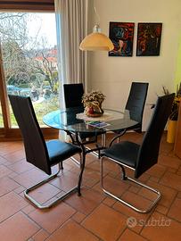 Tavolo rotondo in vetro con sedie nere