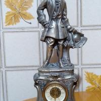 Statuetta antica in metallo con orologio