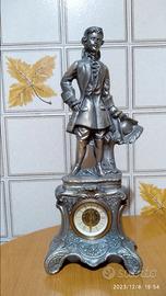 Statuetta antica in metallo con orologio
