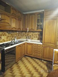 Cucina ad angolo in legno con elettrodomestici