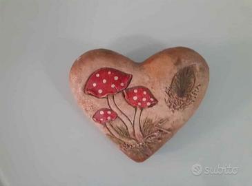 Cuore decorativo in pietra con funghi