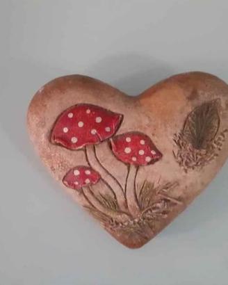 Cuore decorativo in pietra con funghi