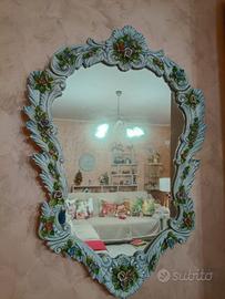 Antico specchio in ceramica con retro in legno.