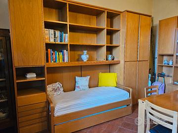 libreria con letto ,tavolo con sedie e cristallier
