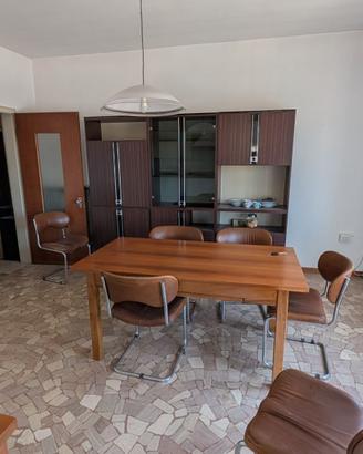 Cucina usata con credenza, tavolo e sedie