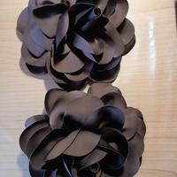 due spille decorative a forma di fiori marroni