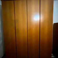 Armadio grande in legno con ripiani e cassetti.