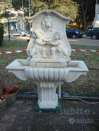 Fontana a muro con putti in cemento bianco