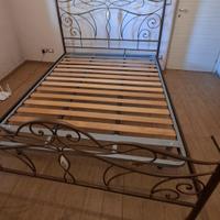 letto in ferro battuto e rete con doghe