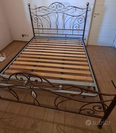letto in ferro battuto e rete con doghe