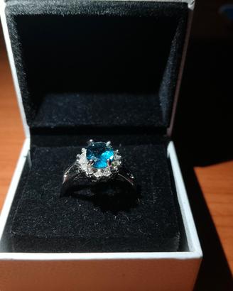 anello con pietra blu e circondato da zirconi