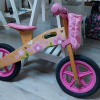 Bicicletta senza pedali in legno con fiori rosa