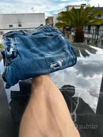 Jeans blu con strappi e macchie di pittura