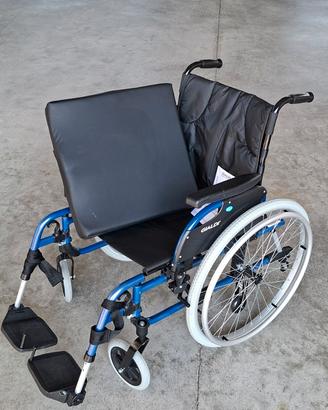 Carrozzina pieghevole e cuscino antidecubito