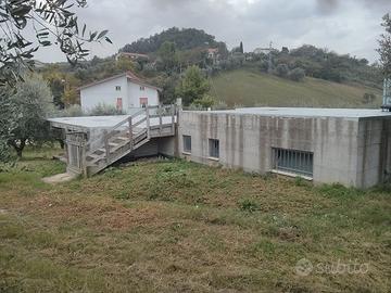 Manufatto in cemento armato circondato da uliveto