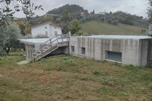 Manufatto in cemento armato circondato da uliveto