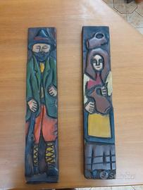 Coppia di pannelli di legno con figure intagliate