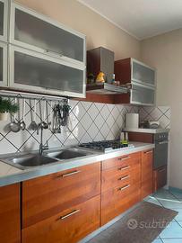 Cucina lineare con tavolo/sedie e elettrodomestici
