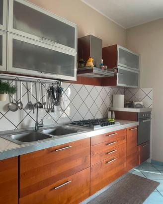 Cucina lineare con tavolo/sedie e elettrodomestici