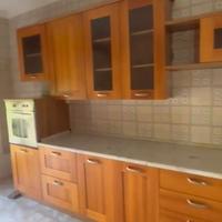 Cucina in legno con elettrodomestici.