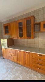 Cucina in legno con elettrodomestici.