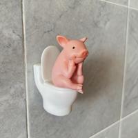 Pig sitting on the toilet