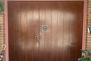 Porta basculante coibentata con porta pedonale
