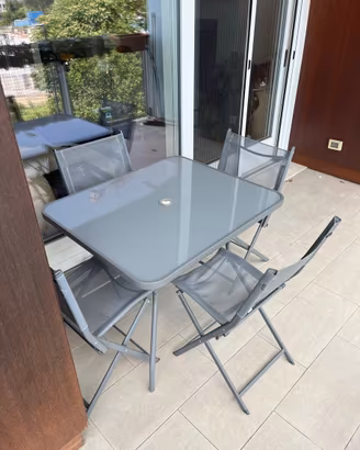 Set tavolo grigio con ripiano in vetro e sedie
