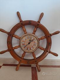 Orologio su timone in legno e quadri vari