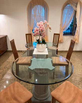 Tavolo in vetro con colonne decorative con sedie