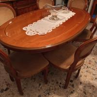 Sala da pranzo con tavolo, sedie e credenza