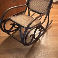 Sedia a dondolo in legno scuro con seduta in ratan