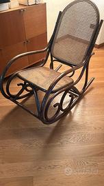 Sedia a dondolo in legno scuro con seduta in ratan