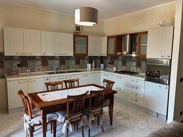 Tavolo con sedie e cucina