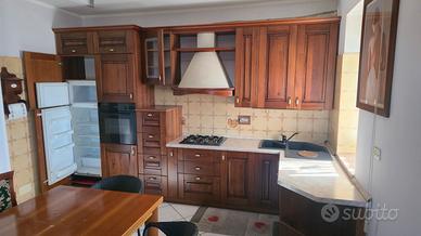 cucina in legno massello tinta noce ad angolo