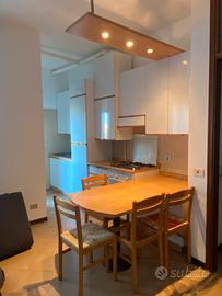 Cucina completa di elettrodomestici, tavolo e sedi