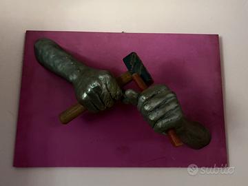 Quadro artistico in rilievo con mani e martello