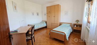 camera con due letti comodini scrivania