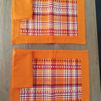 Due tovagliette con tovagliolo arancioni